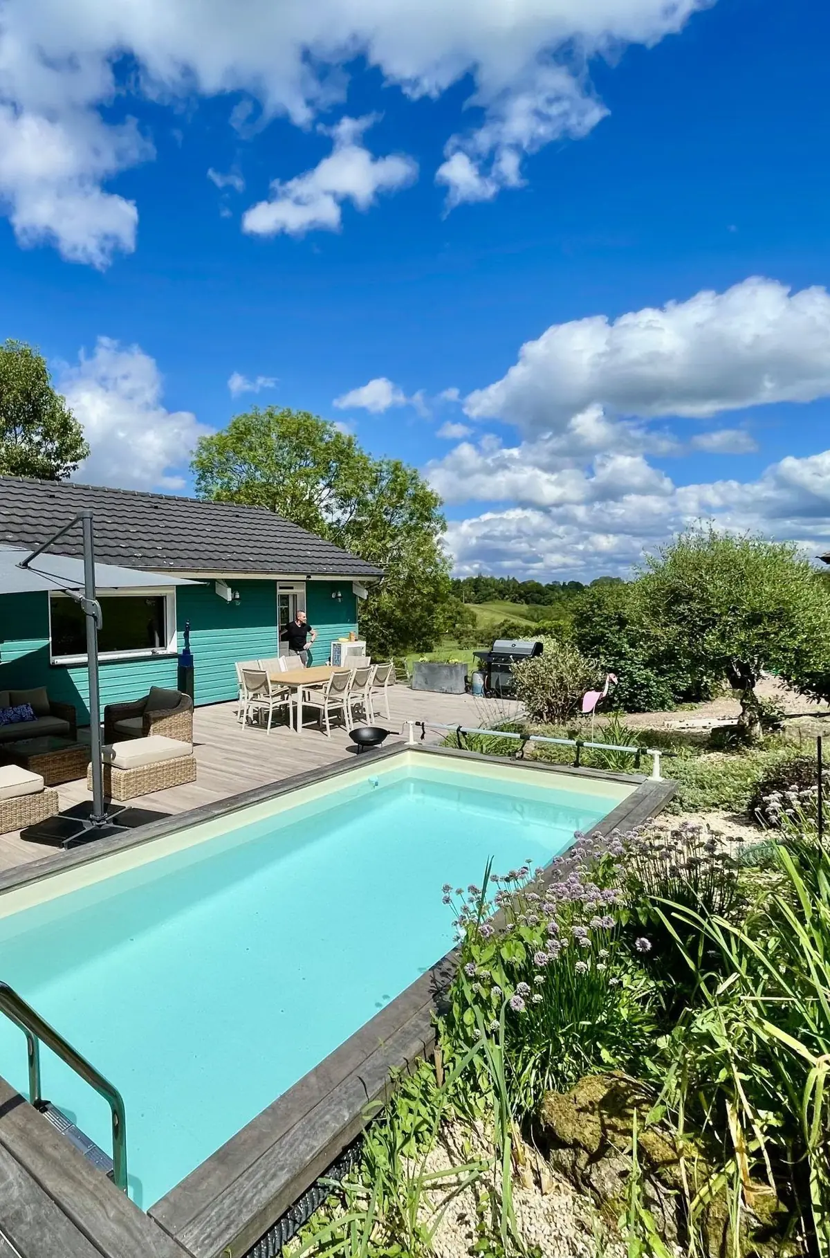 La piscine chauffée le long du Chalet Normand, bordée de sa terrasse de bois